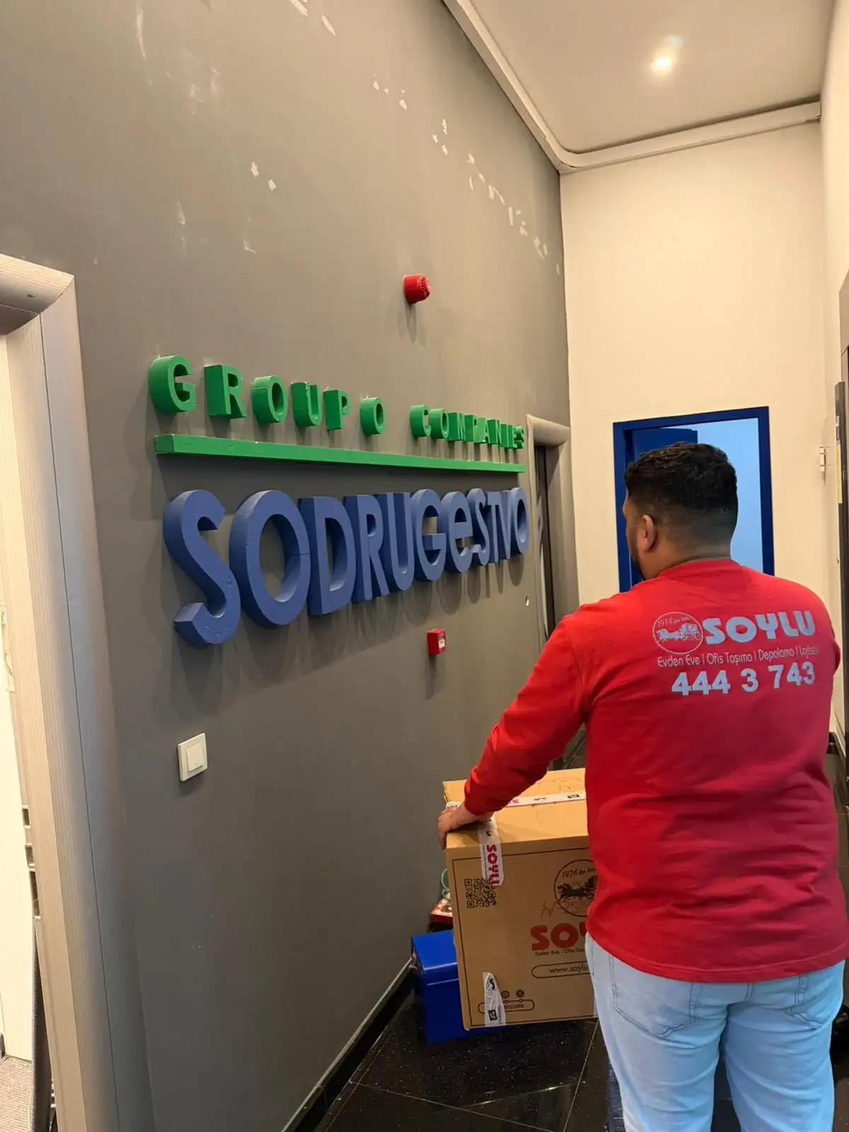 Soylu personeli kurumsal ofis koridorunda koli taşıyor