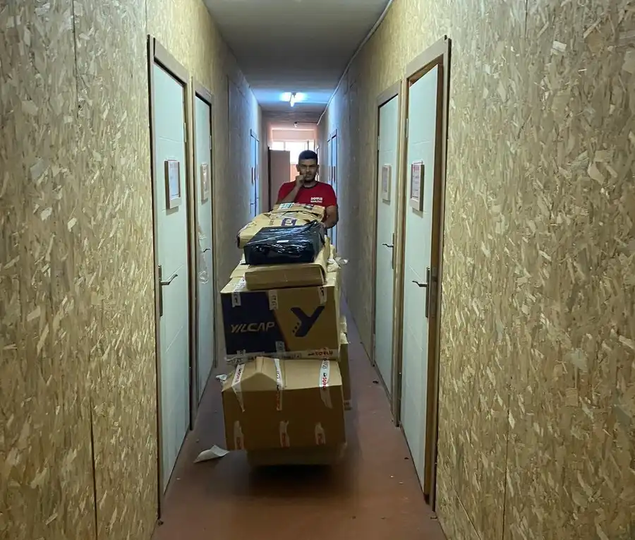 Soylu Nakliyat ekibi paketlenmiş eşyaları koridordan taşıma arabasıyla çıkarıyor
