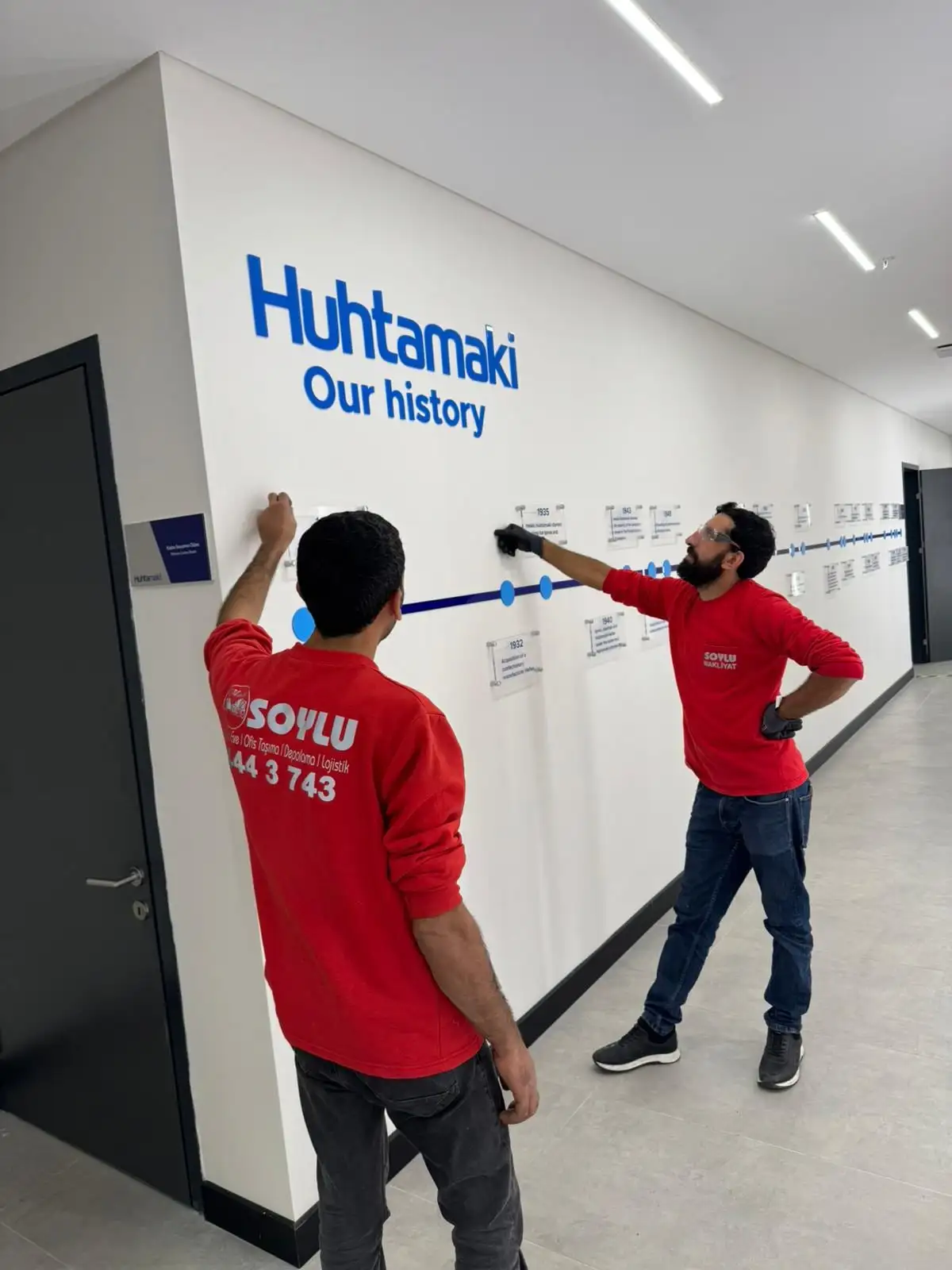 Soylu Nakliyat ekibi kurumsal ofis taşıması sonrası duvar grafiğini yerleştiriyor